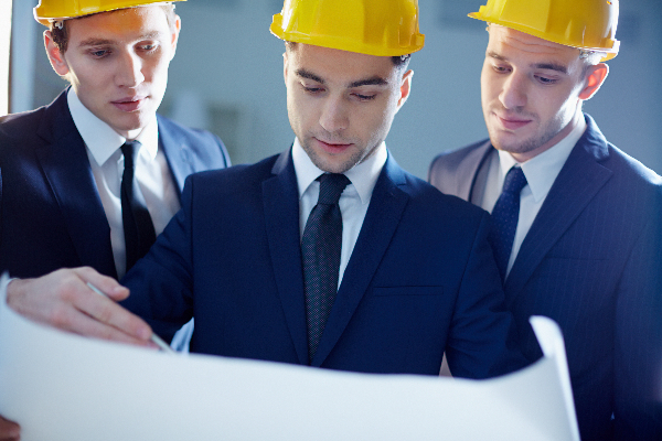 Close-up of workers looking at blue print and planning